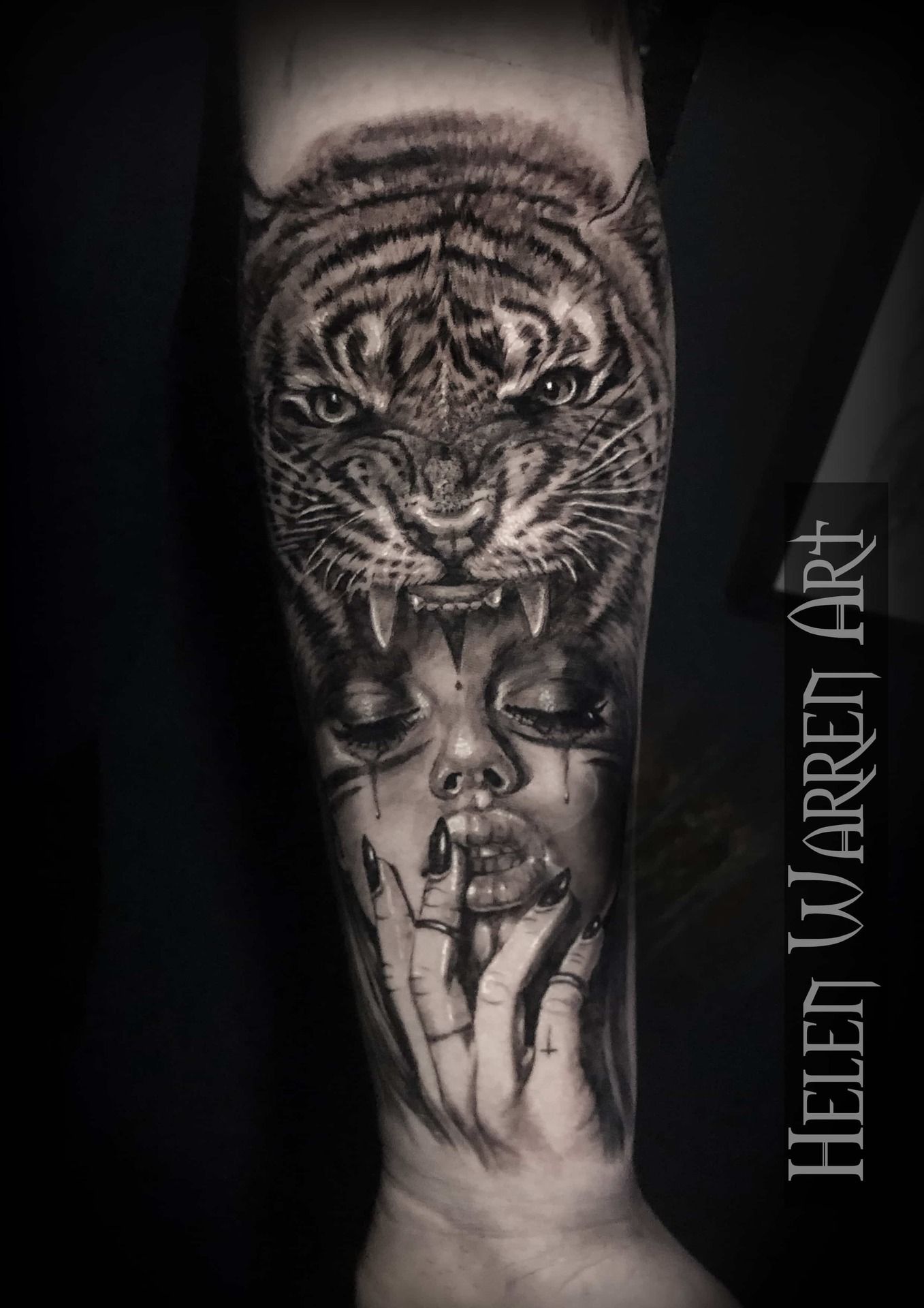 Black and gray tattoo of a tiger roaring above a woman's face with a finger to her lips.